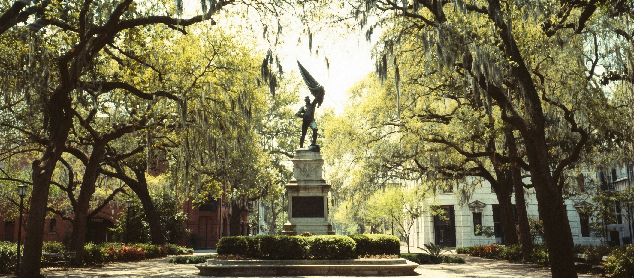 Historic Savannah square with a monument surrounded by live oak trees draped in Spanish moss