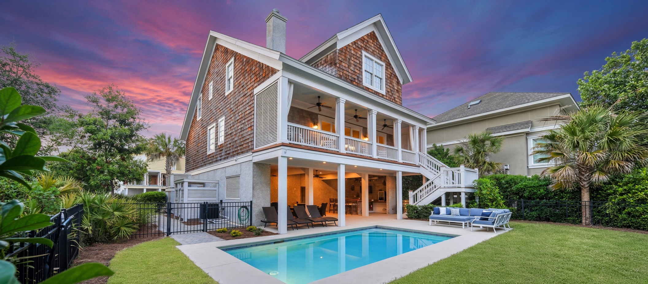 Hilton Head Island vacation rental home with private swimming pool, covered balconies, and outdoor seating at sunset